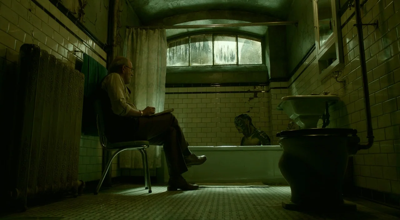 The Shape of Water (2017) movie still: medium — A dilapidated, green-hued tiled bathroom features a vintage tub and exposed radiator pipes. An older…