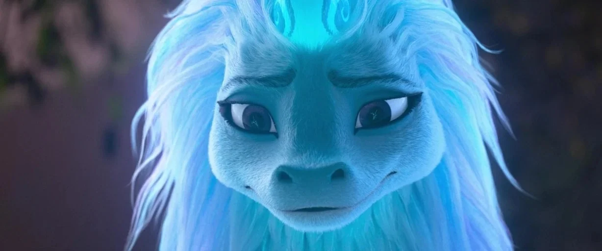 Raya and the Last Dragon (2021) movie still: closeup — A mythical blue dragon creature is shown in a close-up portrait shot. The creature features…