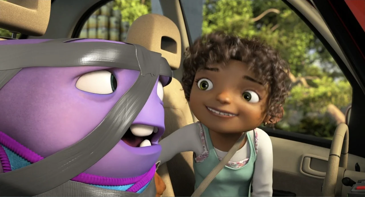 Home (2015) movie still: medium — A 3D animated scene showing the interior of a car during the daytime. A young girl and a purple alien are seated…