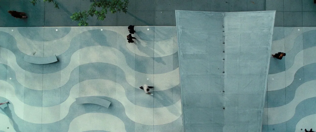 The Secret Life of Walter Mitty (2013) movie still: establishing — A modern public plaza features a concrete ground with a wavy, two-tone pattern.…