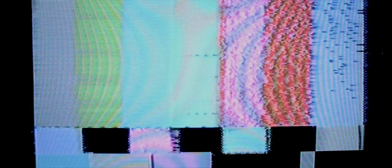 I Trapped The Devil (2019) movie still: establishing — A malfunctioning electronic display shows severe digital corruption and horizontal scanline…