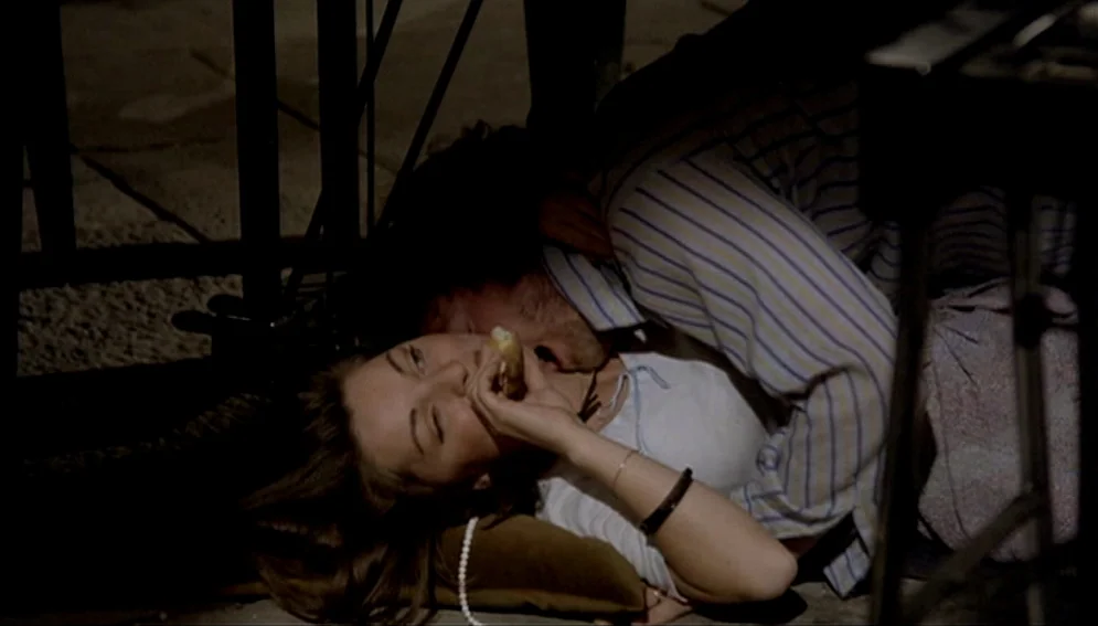 Orchestra Rehearsal (1978) movie still: closeup — A man and woman lie together on a dark floor in a dimly lit space. The man rests his head near the…
