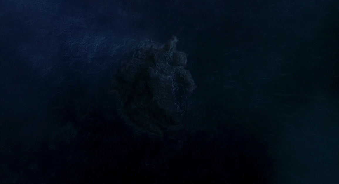 Hellboy (2004) movie still: establishing — A dark rocky outcrop rises from the turbulent sea during a stormy night. White spray highlights the sharp…