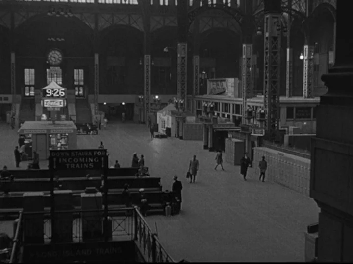 Blast Of Silence (1961) movie still: establishing — A grand, cavernous train station terminal features high vaulted ceilings and metal support…