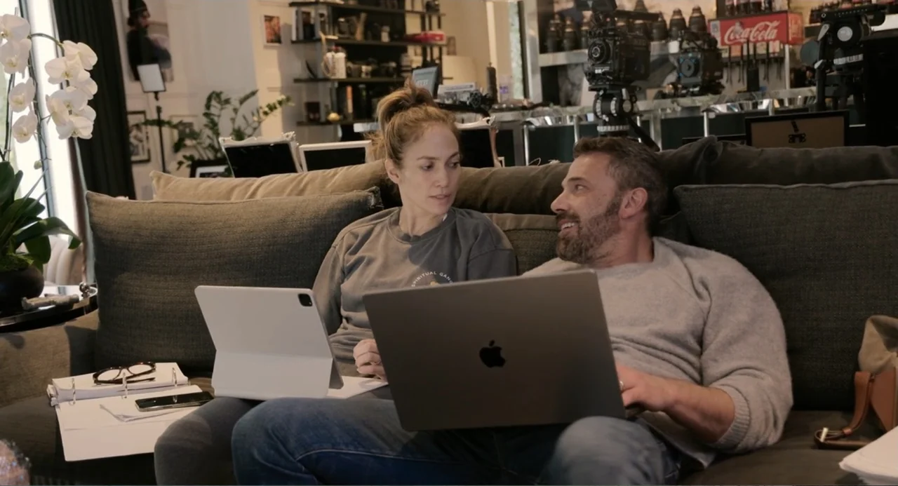 The Greatest Love Story Never Told (2024) movie still: medium — A well-lit contemporary interior with shelves filled with camera equipment and a…