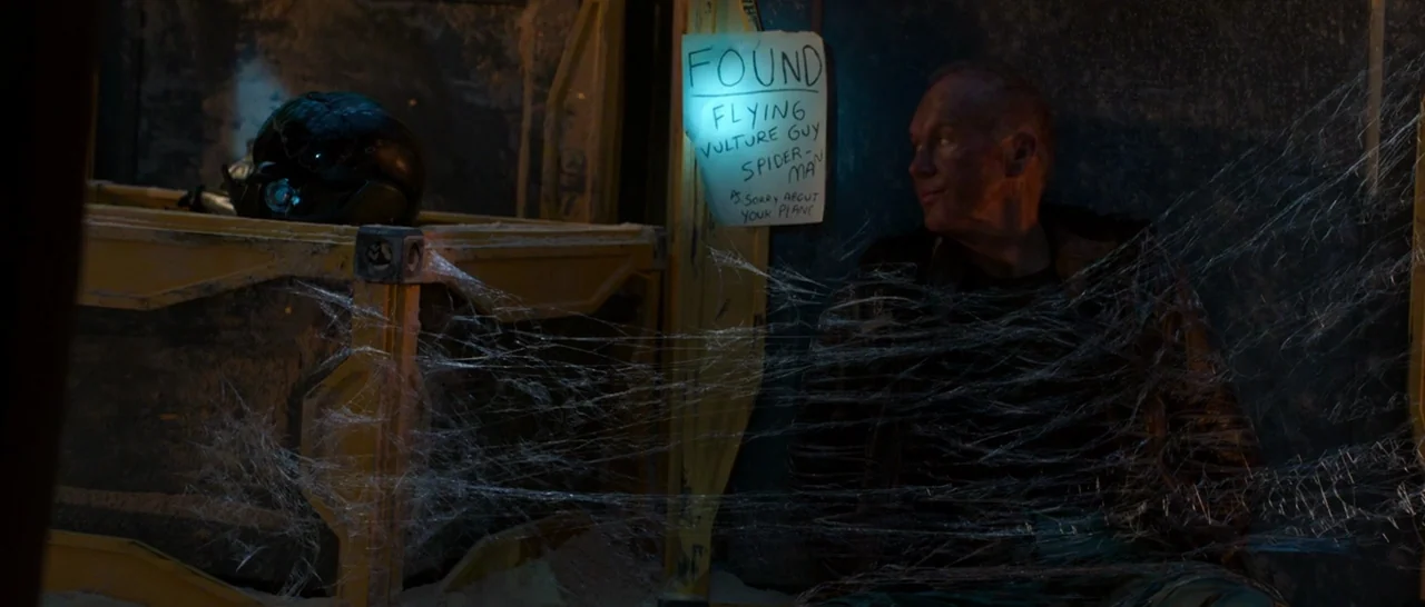 Spider Man: Homecoming (2017) movie still: medium — An industrial dark space features yellow metal crates and a handwritten sign on wall. A…