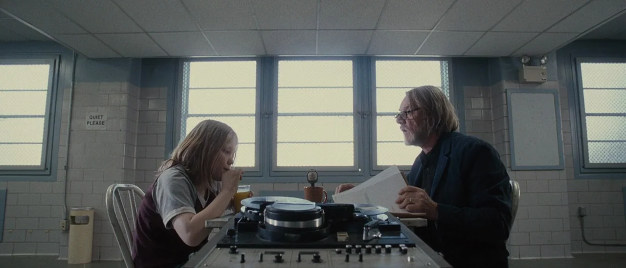 Halloween (2007) movie still: medium — A tiled room with light blue walls and large windows across the back wall. A child and an older man sit…