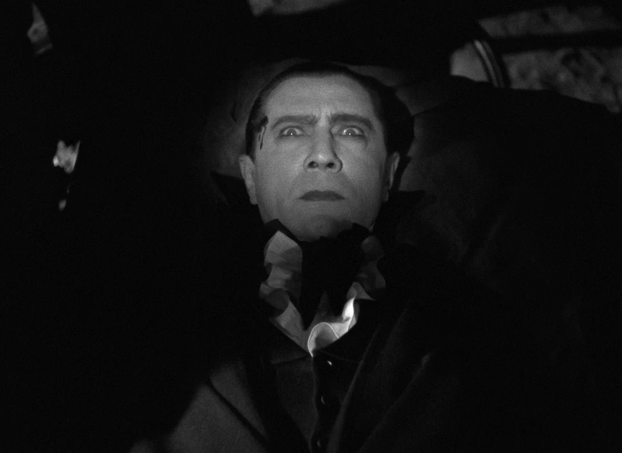 Mark of the Vampire (1935) movie still: closeup — A man lies recumbent within a dark and narrow wooden enclosure. His face is pale and upturned,…