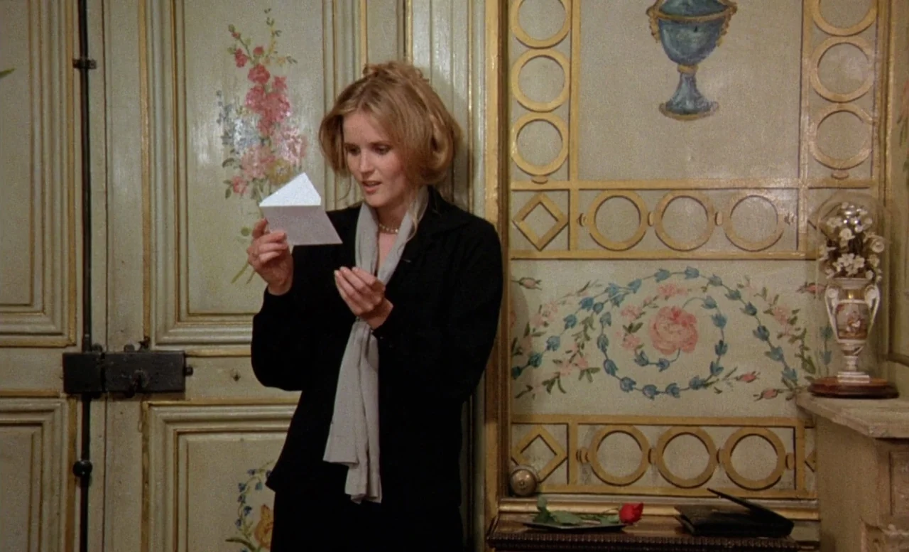 The Beast (1975) movie still: medium — An interior space features pale green walls adorned with hand-painted floral motifs and molding. A woman in a…
