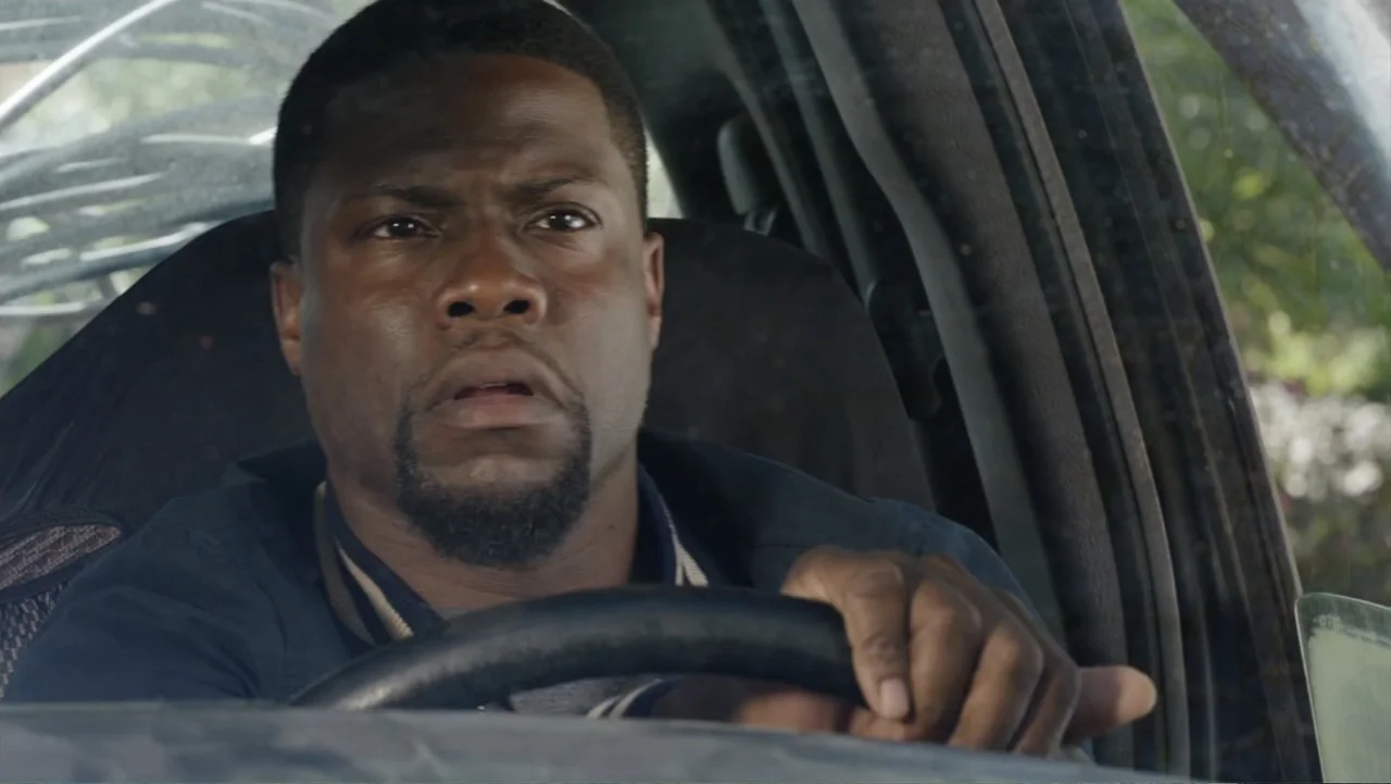 Get Hard (2015) movie still: medium — The interior of a vehicle during the daytime with daylight filtering through the windows. A man in a dark…