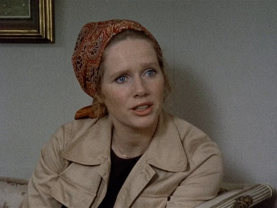 Scenes from a Marriage (1973) movie still: medium — An interior space with a plain, light grey wall and a framed picture hanging. A young woman…