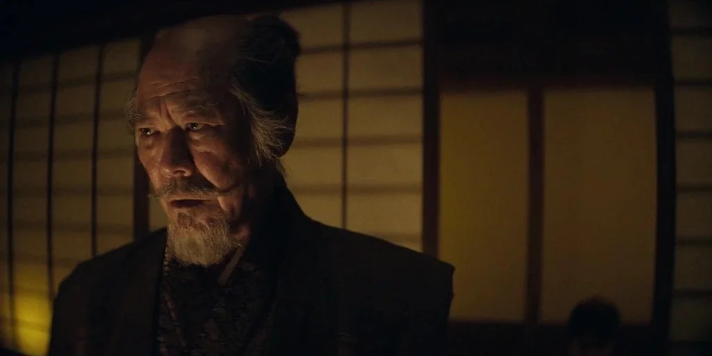 Shogun (2024) movie still: medium — An interior space features traditional paper shoji screen walls with wooden frames. An elderly man with a…