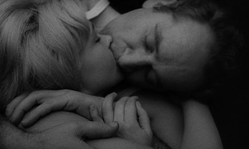 Man Is Not Bird (1965) movie still: closeup — A close-up view shows two people locked in an embrace in a dark space. They are pressing their faces…