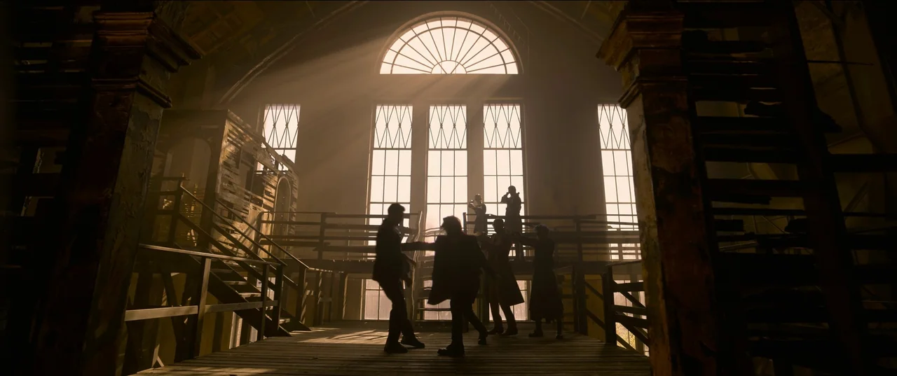 The Matrix Resurrections (2021) movie still: wide — A dark, dilapidated interior space features a wooden platform and large geometric arched…