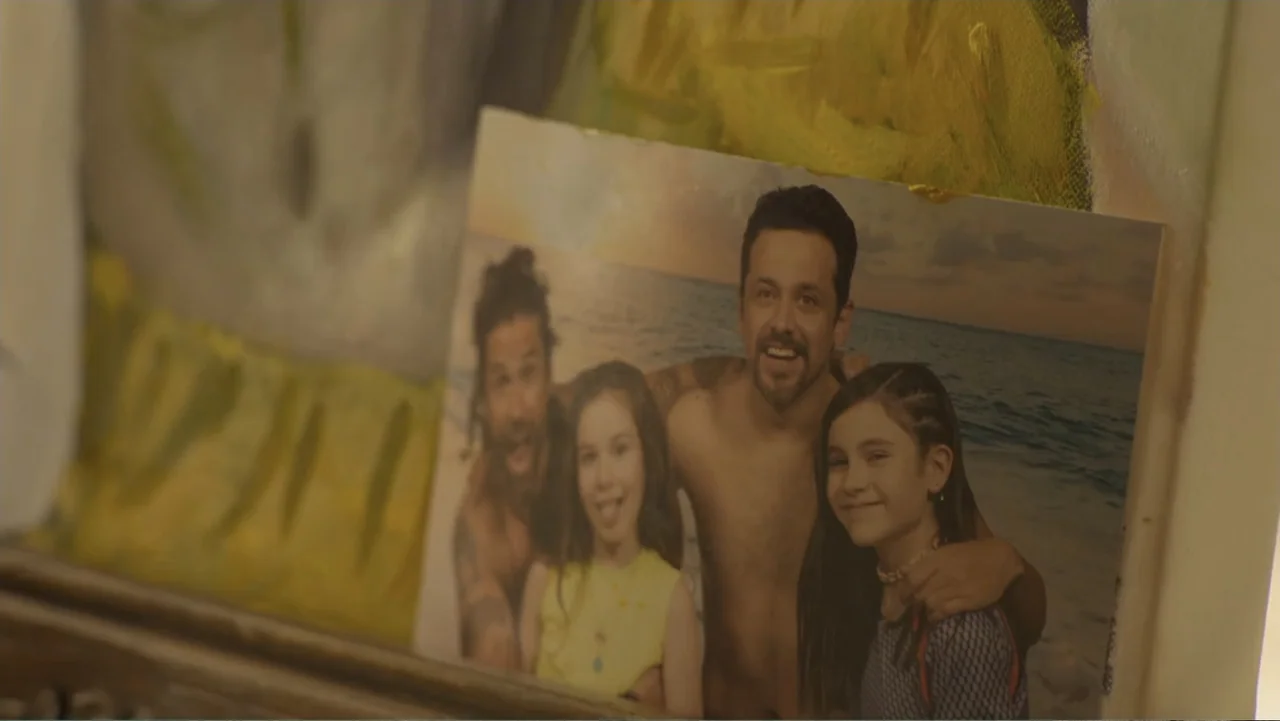 Double Pregnant 2 (2022) movie still: closeup — A close-up photograph sits inside a decorative frame resting on a surface. The photo depicts two…