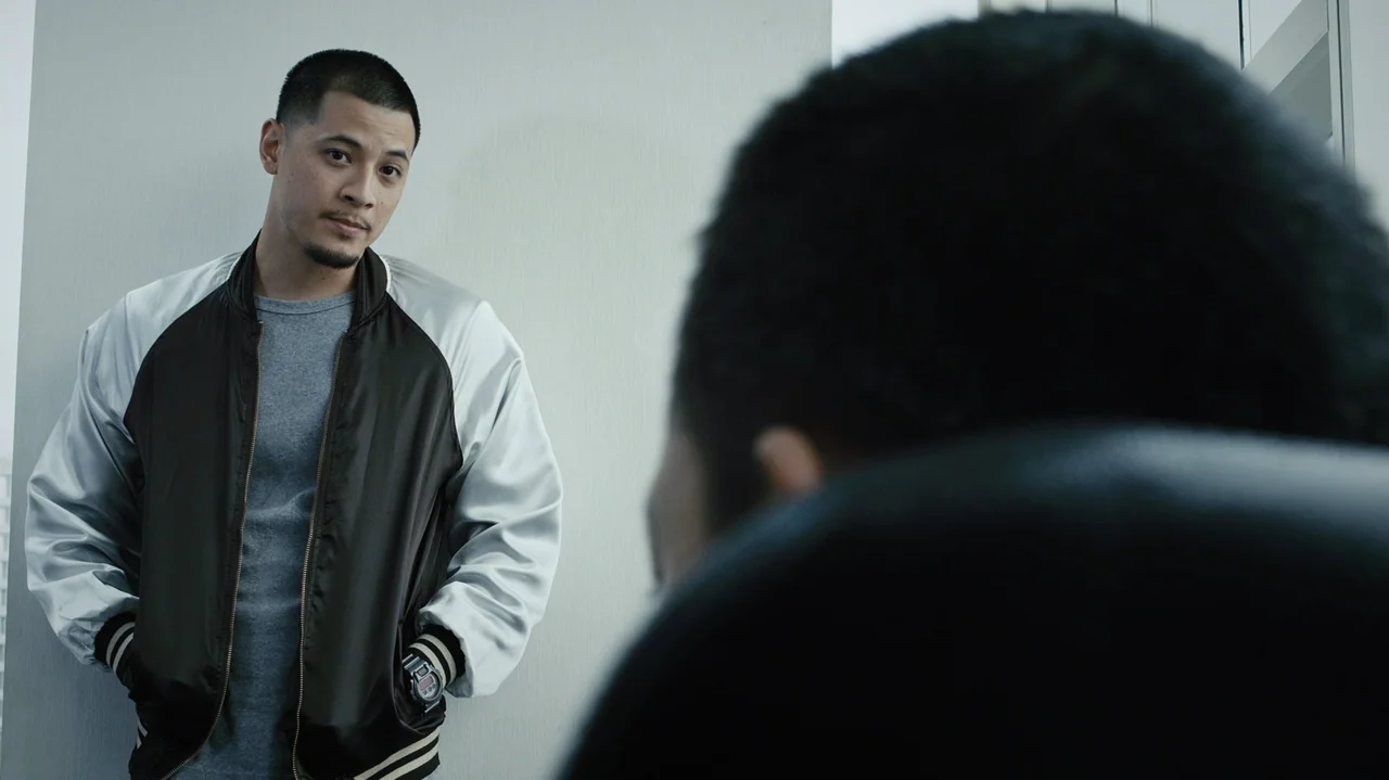 Zero Tolerance (2015) movie still: medium — A modern office interior features light gray paneled walls and plain professional architecture. A man…