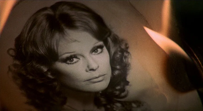 Lisa and The Devil (1973) movie still: closeup — A close-up photograph of a woman's face is curled and illuminated by firelight. The edge of the…
