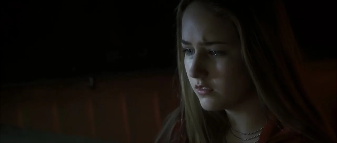 Joy Ride (2001) movie still: closeup — A dark interior space provides minimal background detail behind the subject. A young woman with long blonde…