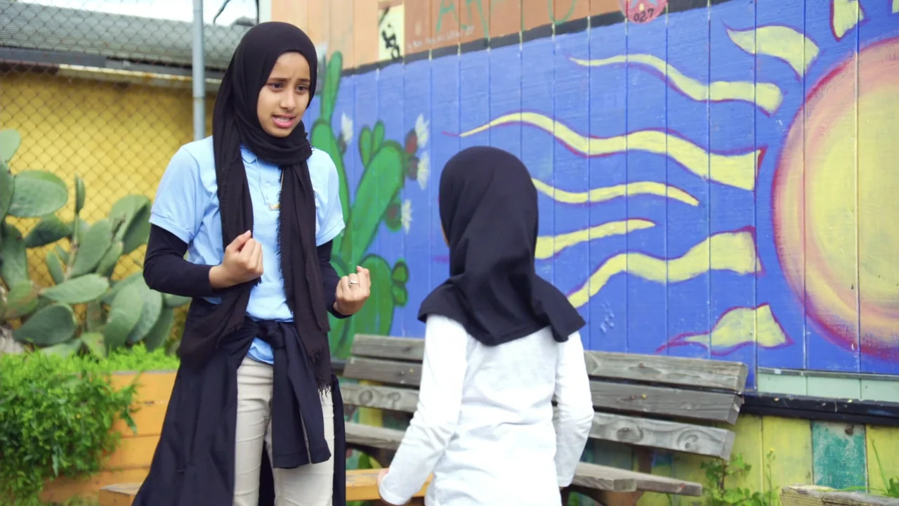 We Are the Dream: The Kids of the Oakland MLK Oratorical Fest (2020) movie still: medium — Two girls stand in front of a colorful wall mural with a…