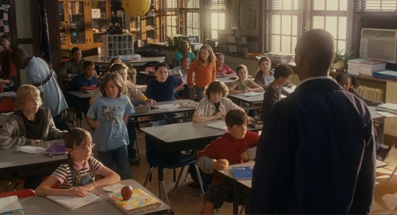 Meet Dave (2008) movie still: wide — An elementary school classroom features rows of desks with students facing the front. A teacher stands with his…