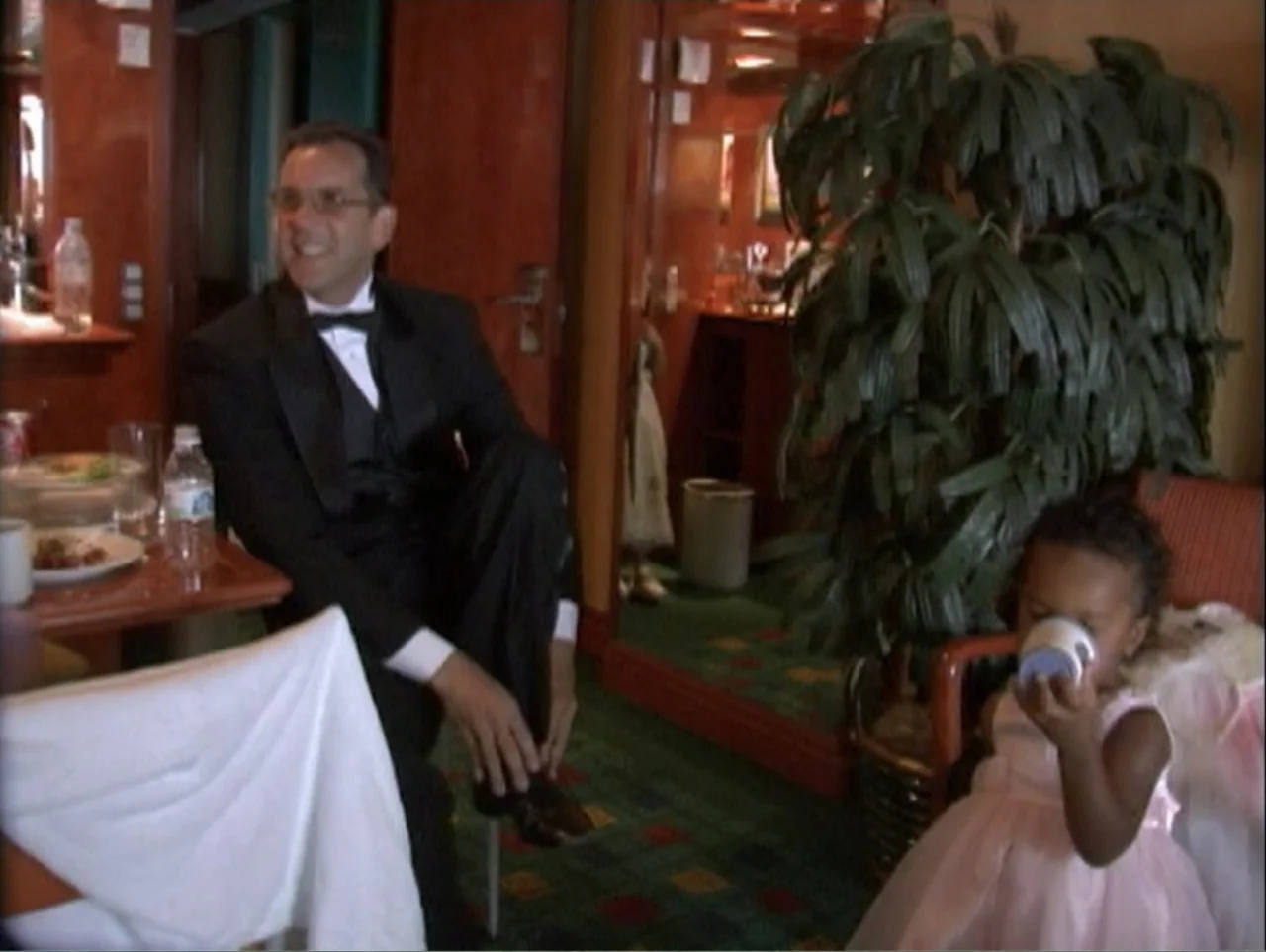 All Aboard! Rosie's Family Cruise (2006) movie still: medium — A wood-paneled room contains a dining table and a large decorative potted plant. A…