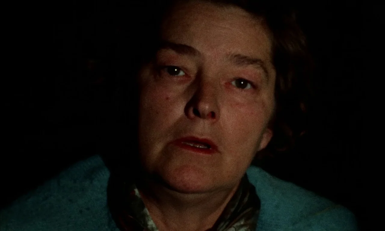 Thriller: A Cruel Picture (1973) movie still: closeup — A woman's face is illuminated in a dark room against an invisible background. She looks…