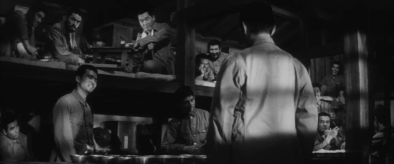 The Human Condition II: Road to Eternity (1959) movie still: medium — A cramped wooden barracks with bunk beds containing numerous men in military…