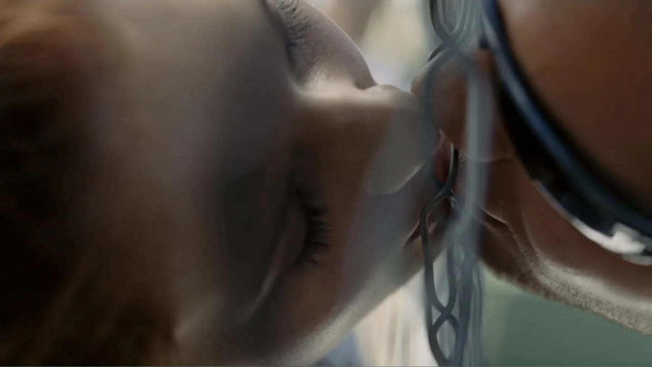 Tomorrow, When the War Began (2010) movie still: closeup — A close up shows two people kissing separated by a metal chain link fence. The fence is…