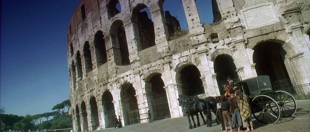 The Portait of a Lady (1996) movie still: wide — The Colosseum facade shows weathered stone arches with inscribed marble plaques near the top. A…
