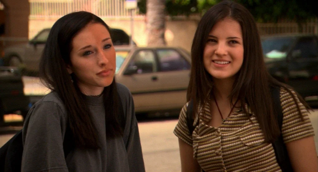 Me and You and Everyone We Know (2005) movie still: medium — Two teenage girls stand in an outdoor parking lot with cars parked behind them. The…