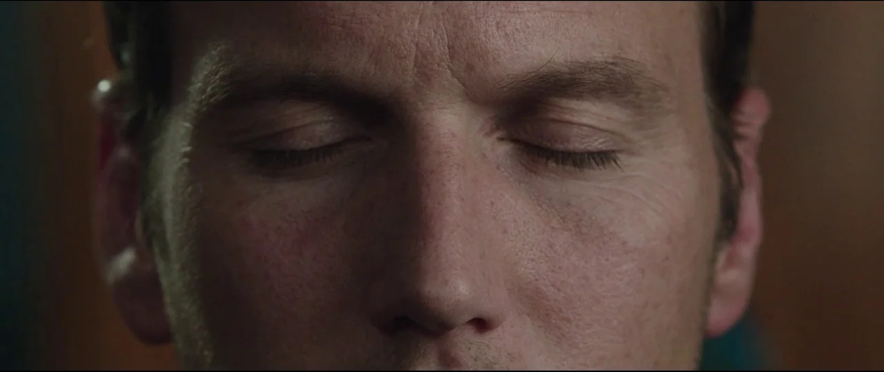 Insidious: Chapter 2 (2013) movie still: closeup — A close-up frame shows only the face of a man. His eyes are shut and his head is positioned…
