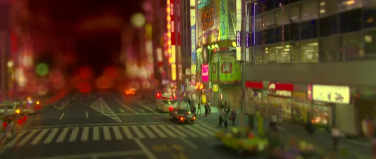 Enter The Void (2009) movie still: wide — A dense urban intersection is lit by vibrant neon signage and glowing vehicle lights. The high-angle…