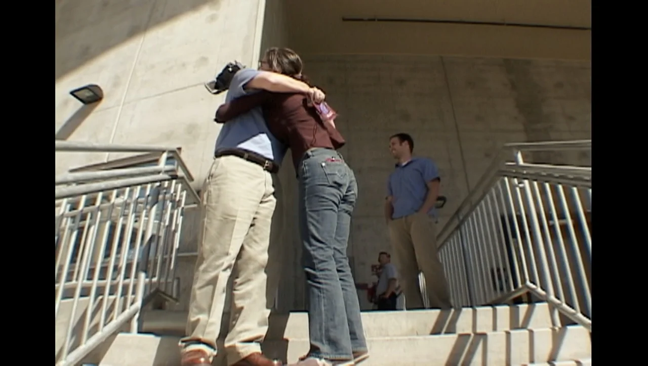 The Trials of Ted Haggard (2009) movie still: fullbody — Concrete stairs leading up to a large building exterior in bright daylight. A couple…