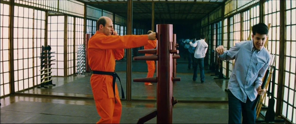 Kick Ass (2010) movie still: wide — A spacious room features floor-to-ceiling shoji screens lining the walls and full-length mirrors. An instructor…