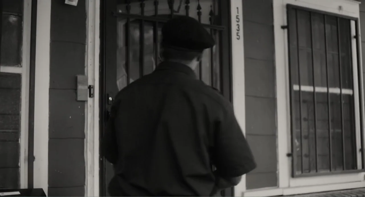 What You Gonna Do When the World's on Fire? (2019) movie still: medium — A residential building exterior features a dark metal security gate and…
