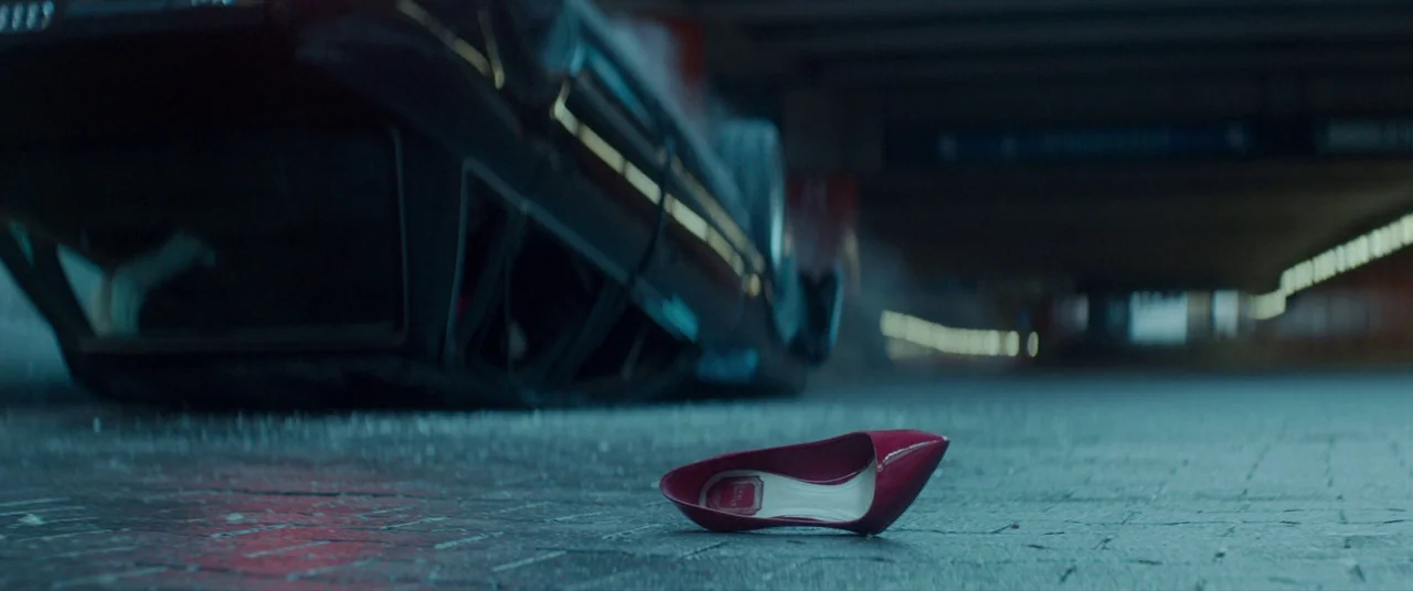 Atomic Blonde (2017) movie still: closeup — A dark urban underpass features wet, reflective pavement under an overhead concrete ceiling. A single…