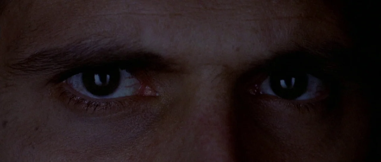 The Bird With The Crystal Plumage (1970) movie still: closeup — A close-up view focuses on a pair of human eyes set in darkness. The subject stares…