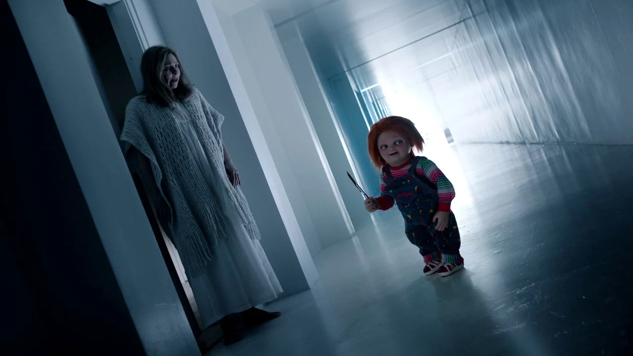 Cult of Chucky (2017) movie still: fullbody — A brightly lit clinical corridor features clean white walls and polished reflective flooring. An older…