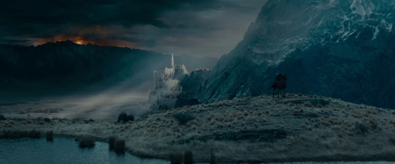 The Lord of the Rings: The Fellowship of the Ring (2001) movie still: establishing — A vast, rugged landscape features a distant white stone castle…