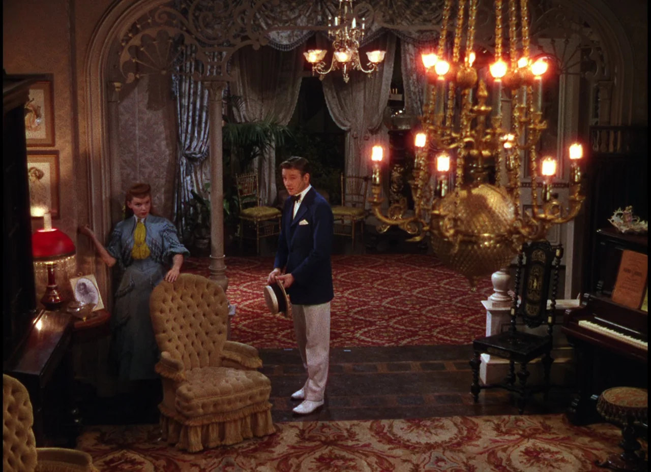 Meet Me In St. Louis (1944) movie still: fullbody — An opulent Victorian parlor features ornate filigree arches, heavy patterned carpeting, and…