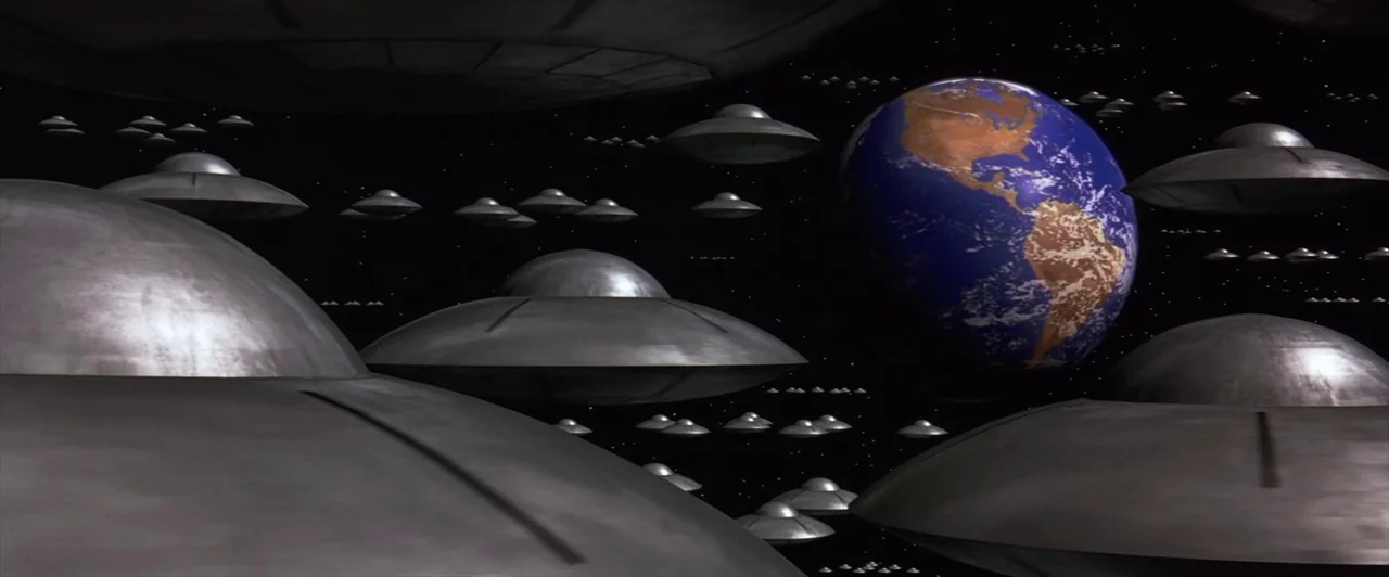Mars Attacks! (1996) movie still: establishing — A vast armada of metallic disc-shaped spacecraft drifts through the void of deep space. The planet…