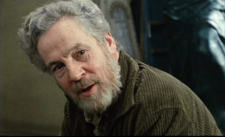 After The Rehearsal (1984) movie still: closeup — A man stands inside a building with neutral walls. He looks at the camera with his mouth slightly…