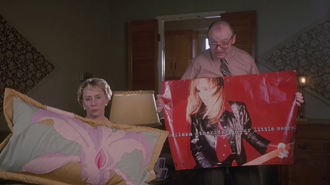 But I’m A Cheerleader (1999) movie still: medium — An interior bedroom features patterned wallpaper and a large upholstered bed with decorative…