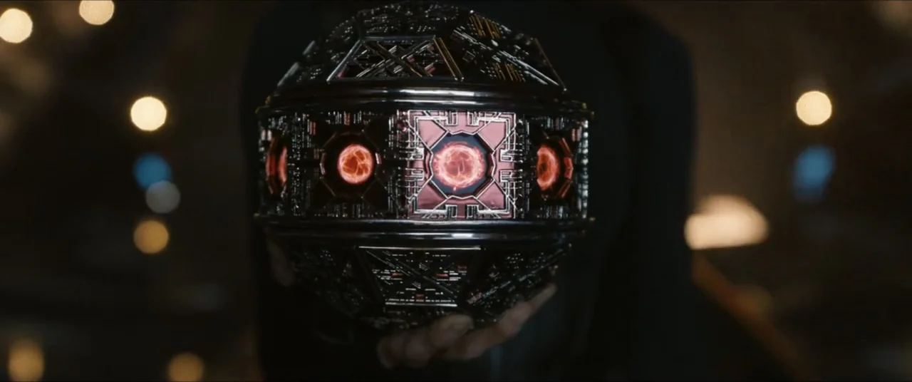 Star Trek: Section 31 (2025) movie still: closeup — A dimly lit interior space contains a complex, dark metallic sphere with glowing red panels. A…