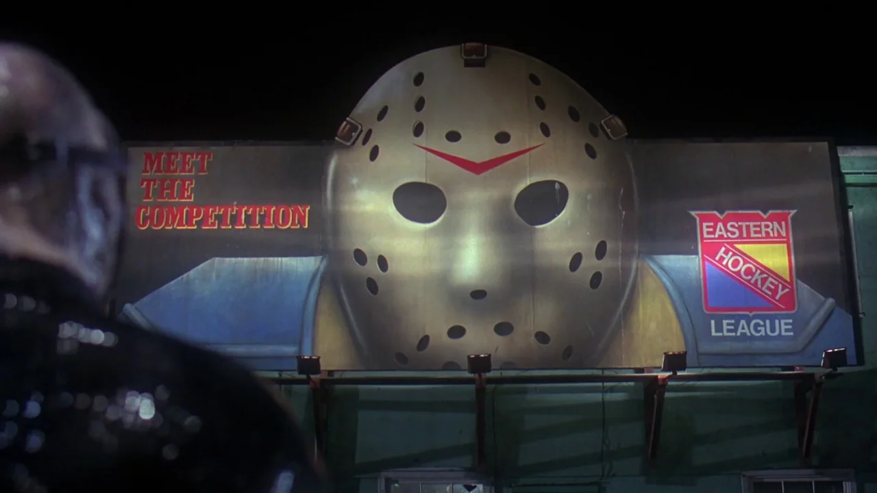 Friday the 13th Part VIII: Jason Takes Manhattan (1989) movie still: medium — A night scene shows a large promotional billboard featuring a hockey…