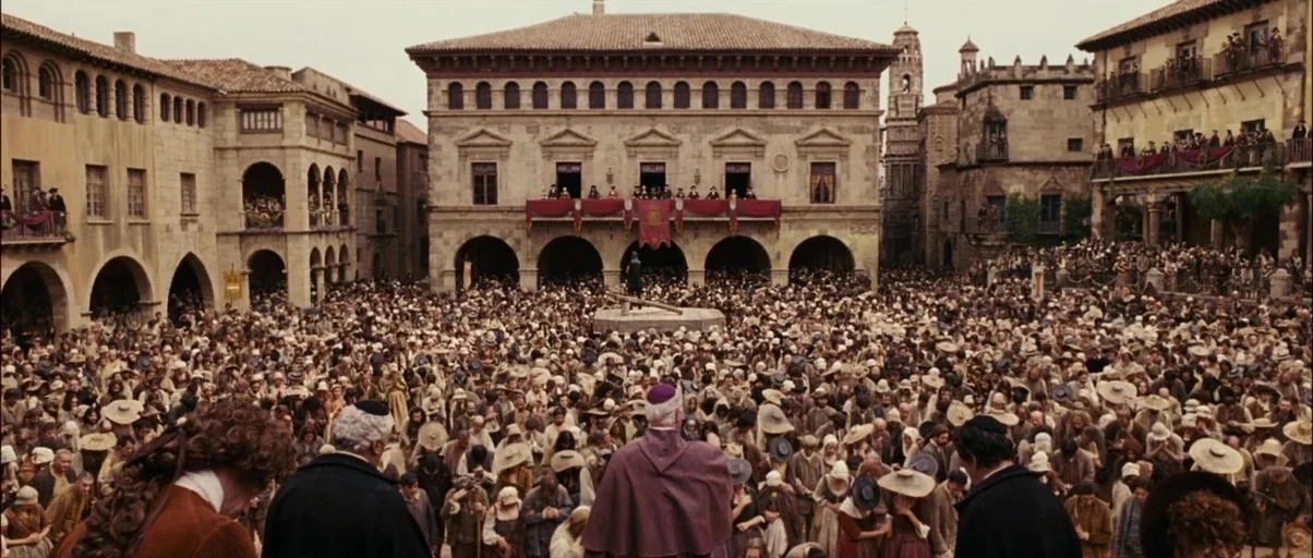 Perfume: The Story of a Murderer (2006) movie still: wide — A dense crowd fills a historic town square beneath a stone building with balconies. A…