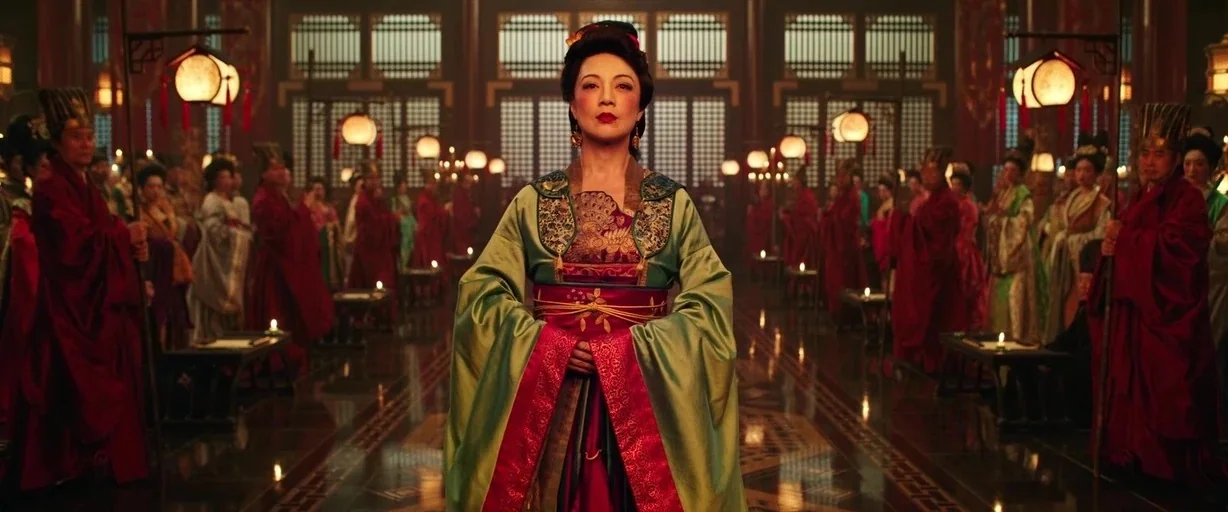 Mulan (2020) movie still: fullbody — A spacious hall with wooden latticework and numerous hanging paper lanterns. A woman stands in the center while…