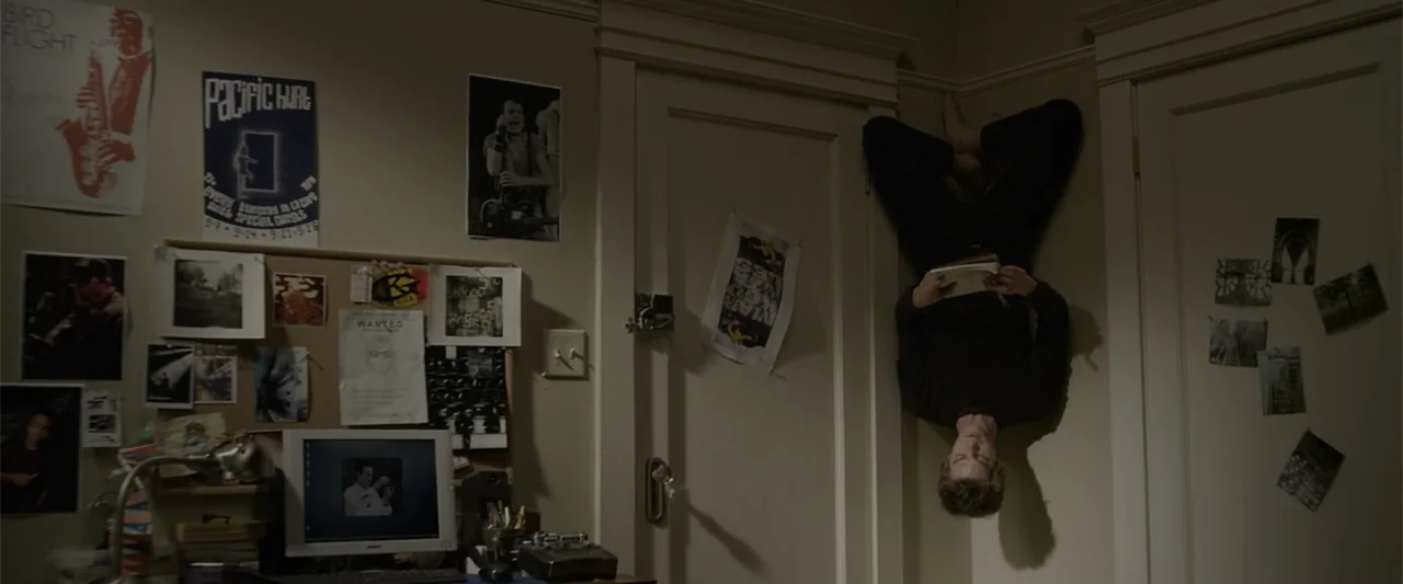 The Amazing Spider-Man (2012) movie still: medium — A cluttered bedroom wall features various posters, photographs, and a computer monitor. A young…