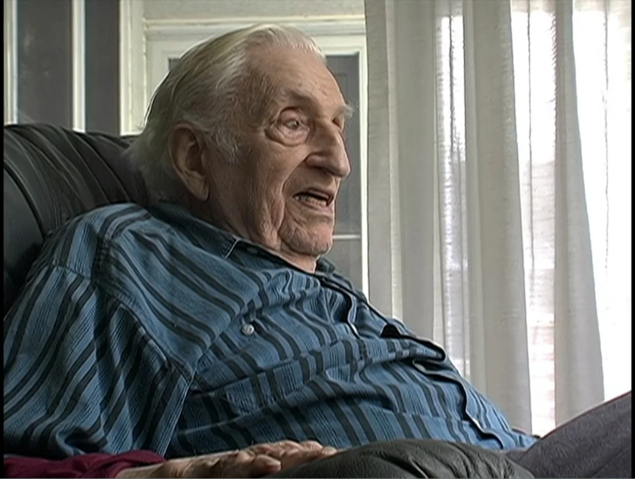 First Cousin Once Removed (2012) movie still: medium — A residential room features a white curtained window behind an elderly man. The man sits in a…