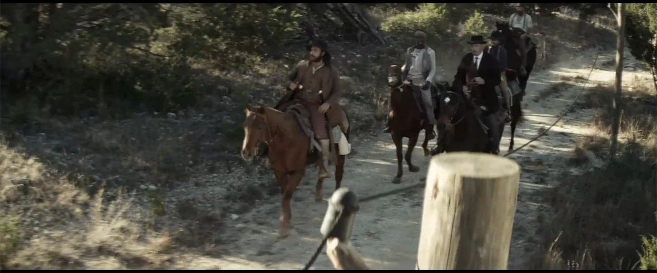 Matar o morir (1984) movie still: wide — A group of men on horseback travels along a dry, rugged dirt trail. They are dressed in period-appropriate…